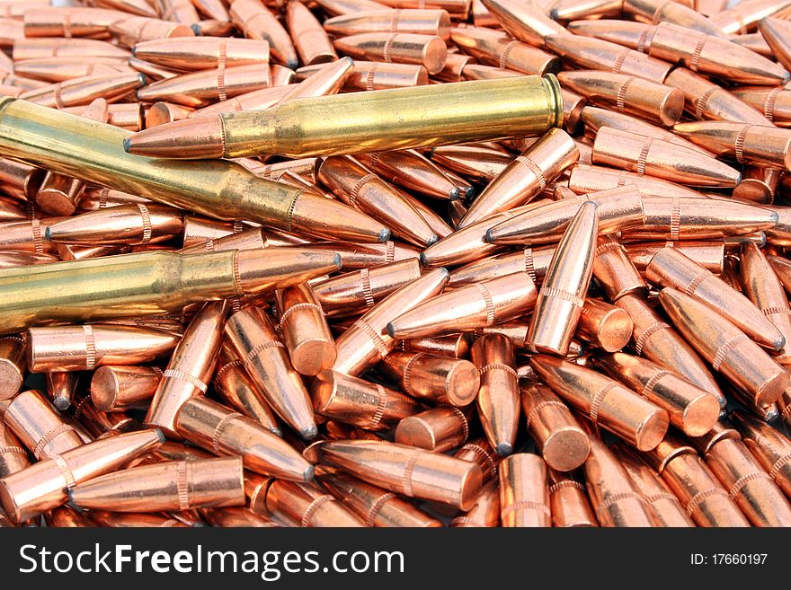 Pile of loose bullets with two loaded cartridges laying on top. Pile of loose bullets with two loaded cartridges laying on top.