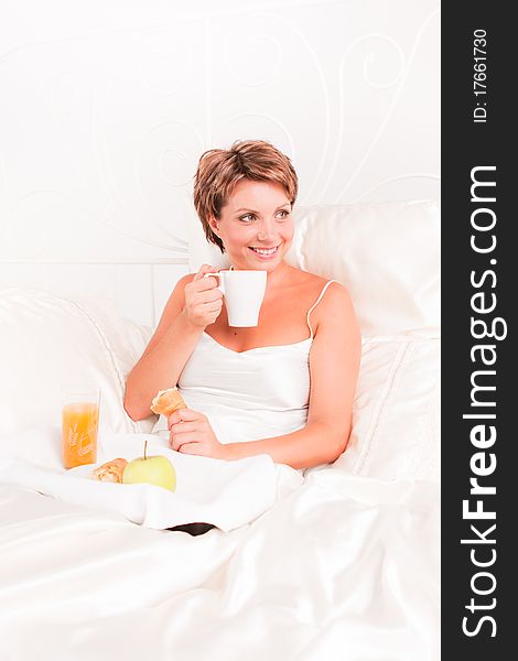 Beatiful woman having breakfast in white bed. Beatiful woman having breakfast in white bed