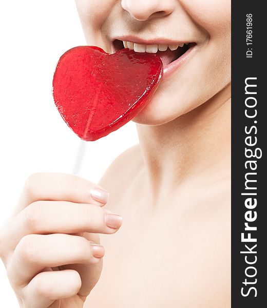 Closeup shot of girl with red heart lolipop isolated on white