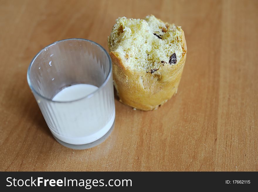An image of a cake and a glass with some milk on a table. An image of a cake and a glass with some milk on a table
