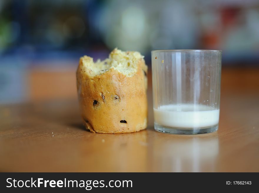 An image of a cake and a glass with some milk on a table. An image of a cake and a glass with some milk on a table