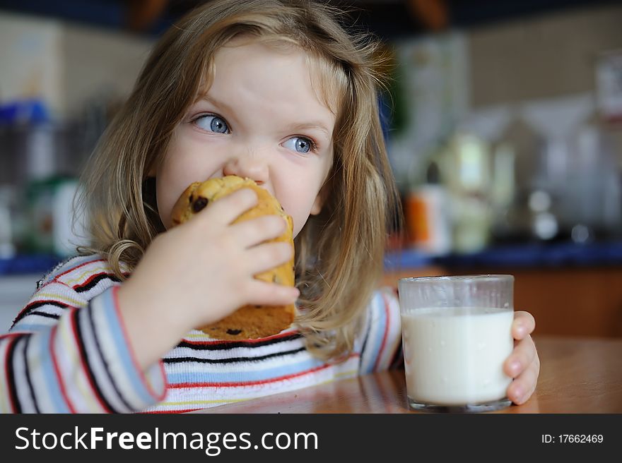 An image of a girl eating cookie with milk. An image of a girl eating cookie with milk