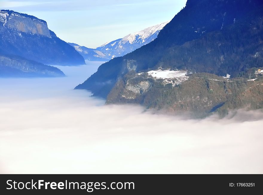 View over a valley of clouds filling. View over a valley of clouds filling