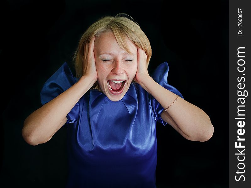 Girl in a blue dress covered her ears with his hands, closed her eyes and screams. Girl in a blue dress covered her ears with his hands, closed her eyes and screams