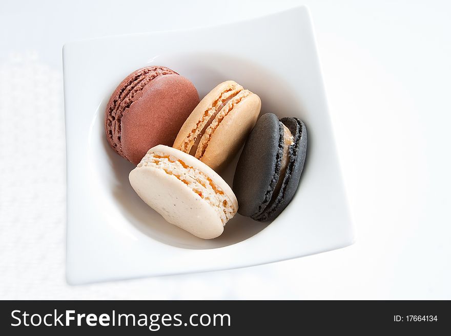 A selection of french macaroons in a white dish. A selection of french macaroons in a white dish
