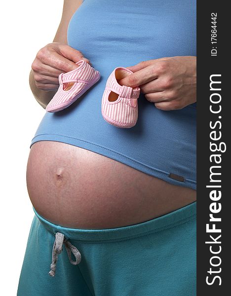 Pregnant woman profile with tiny shoes in the hands over white background. Pregnant woman profile with tiny shoes in the hands over white background