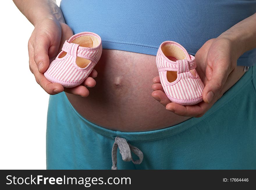 Pregnant woman profile with tiny shoes in the hands over white background. Pregnant woman profile with tiny shoes in the hands over white background