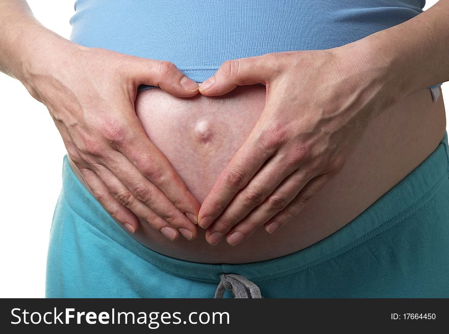 Stomach of pregnant woman with heart shape hands over white background. Stomach of pregnant woman with heart shape hands over white background