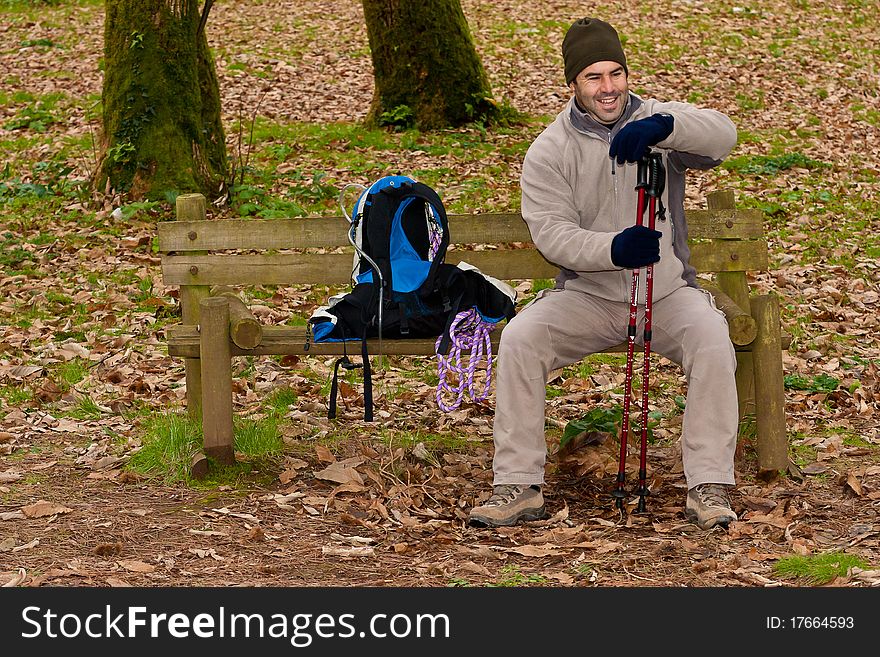 Hiker resting on a forest park bench. Hiker resting on a forest park bench