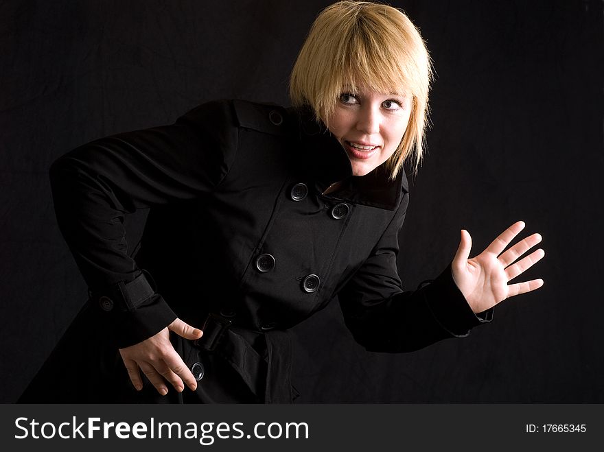 Blond woman in black trench coat.