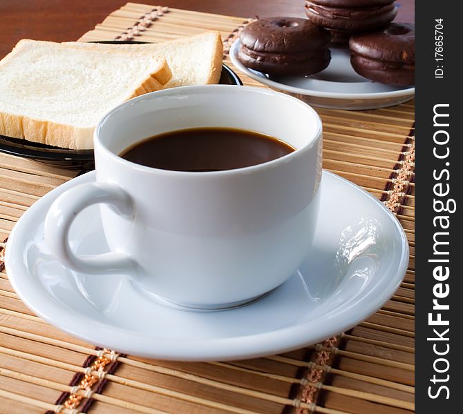 Cup of coffee and bread on table