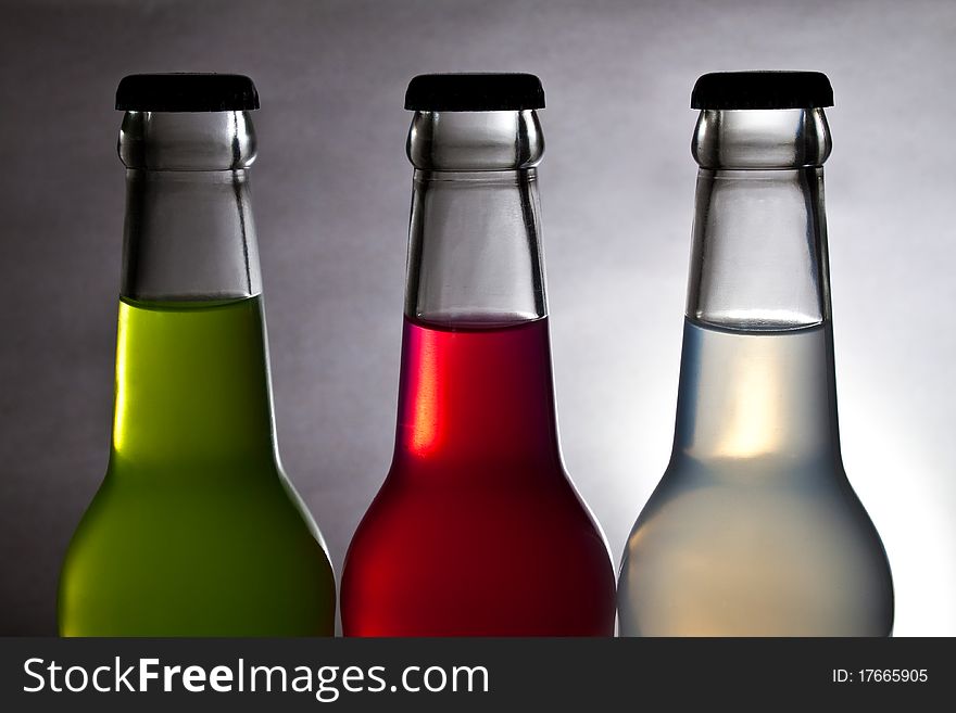 Three colorful bottle of drink on light background