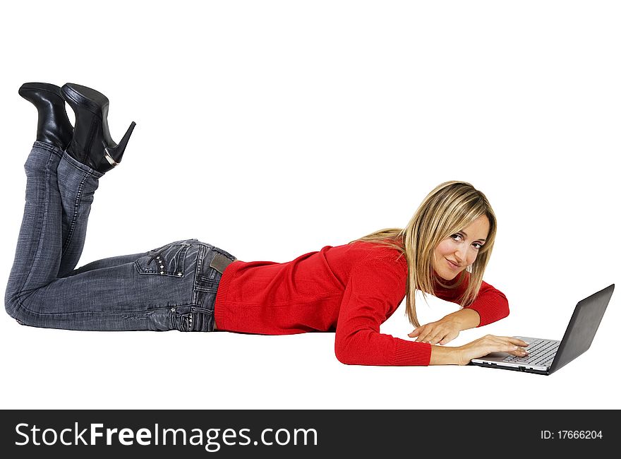 Happy working woman sitting on the floor with her laptop