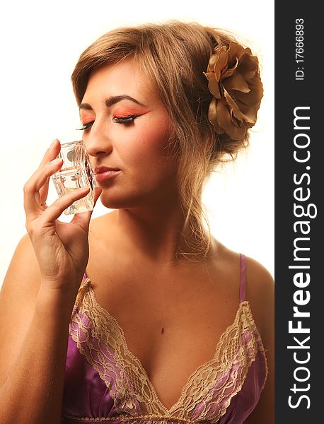 Beautiful young woman smelling perfume