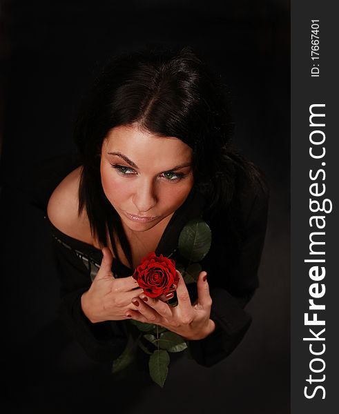 Beautiful girl with red rose standing in the dark. Beautiful girl with red rose standing in the dark