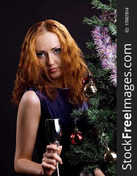 Young beauty red woman and christmas tree in dark