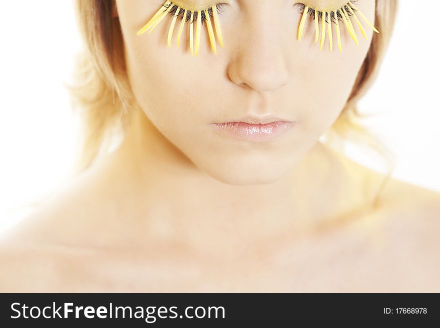 Beautiful young woman wearing yellow petal eyelashes. Beautiful young woman wearing yellow petal eyelashes