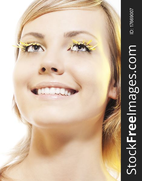 Beautiful young woman wearing yellow petal eyelashes. Beautiful young woman wearing yellow petal eyelashes