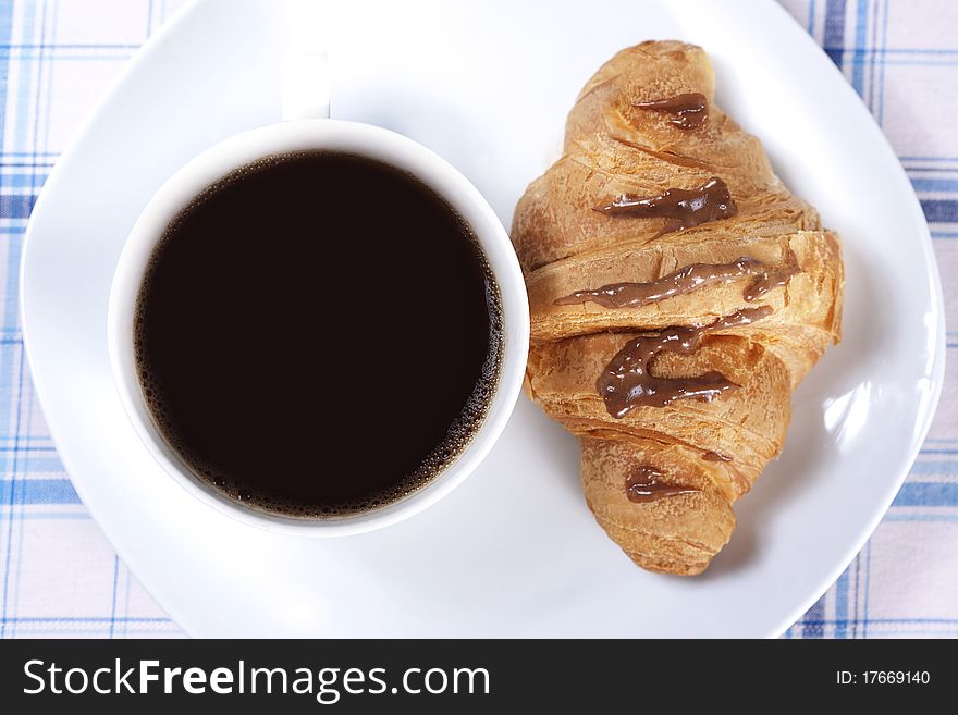 Cup of black coffee and chocolate croissant. Cup of black coffee and chocolate croissant