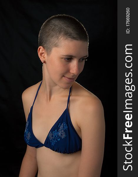 Shaved girl in bikini top isolated on black