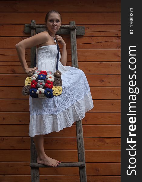 Girl in white sundress on a wooden step-ladder. Girl in white sundress on a wooden step-ladder