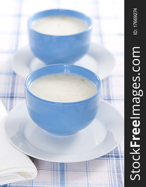 Two blue bowls of onion pureed soup