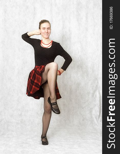 Studio shot of girl dancing cancan in red scottish skirt