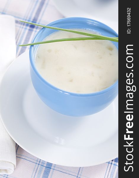 Two blue bowls of onion pureed soup with leek