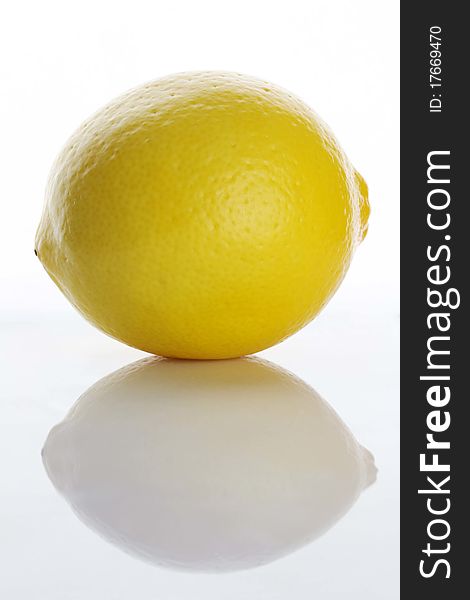 Single lemon with reflection on white