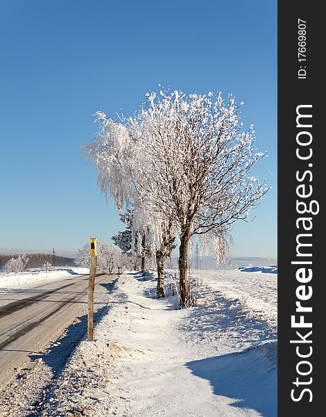 Winter road on a sunny frosty day with blue sky