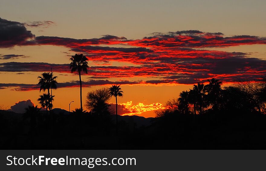 The photo presents the last few minutes of the sunset in the desert which makes the clouds look like burning flames over the desert of Phoenix, Arizona,America. The photo presents the last few minutes of the sunset in the desert which makes the clouds look like burning flames over the desert of Phoenix, Arizona,America.