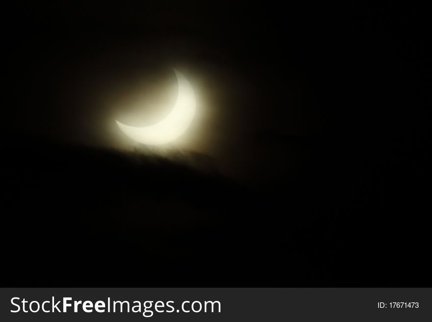 This is a shot of the partial Eclipse of the Sun with a cloudy sky, but not on the part of sun that was visible. Taken the 4th of January 2011, in the south of Milan, Italy.