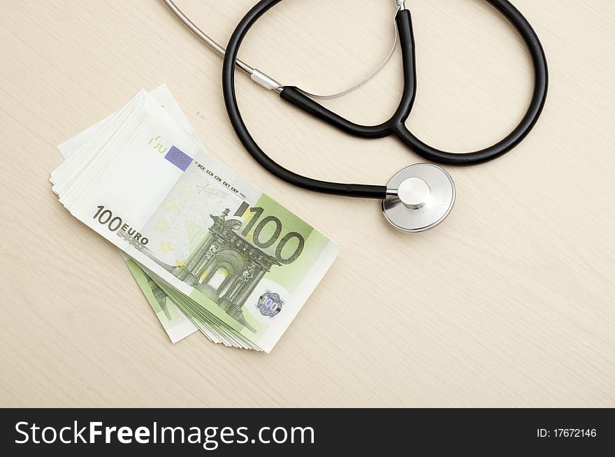 Many Euro bank notes with a stethoscope. Health costs.