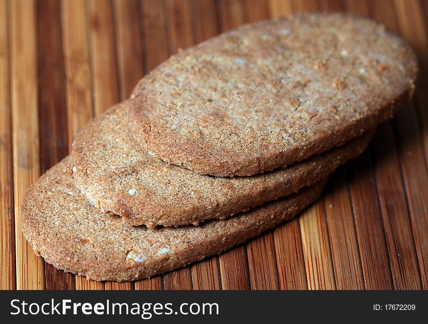 Macro shot of whole wheat biscuits over wooden background.