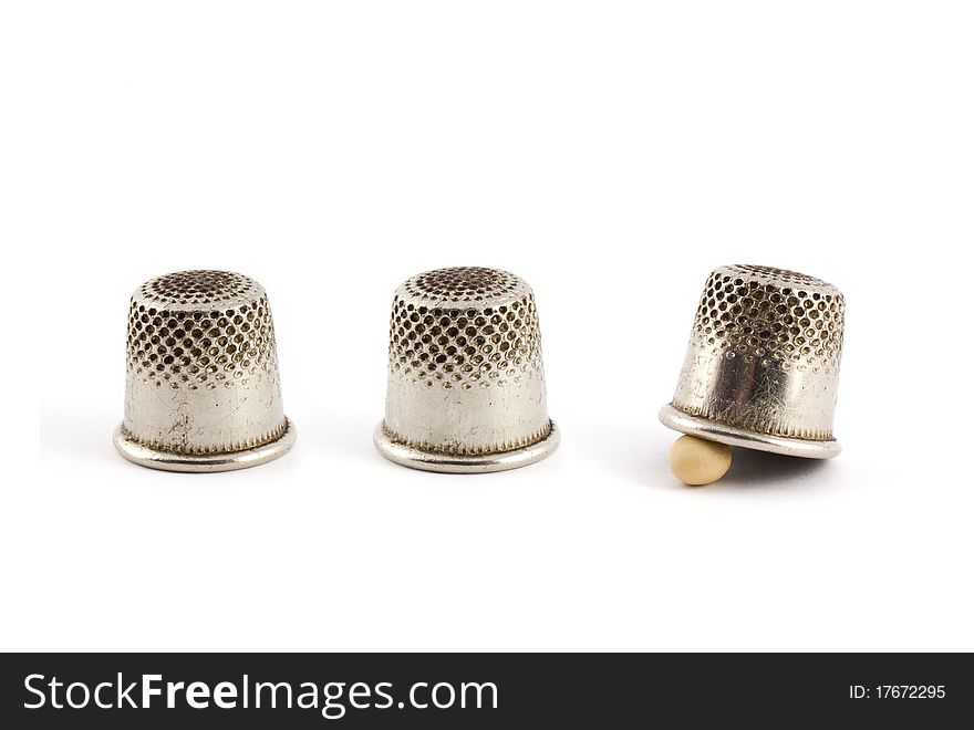 Thimble and pea isolated on white background