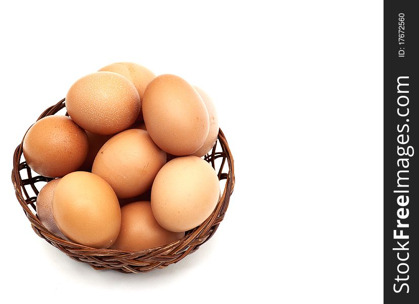 Few fresh raw brown eggs in a basket over white