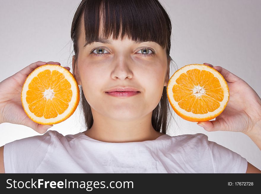 Attractive caucasion girl with two oranges in hands. Artistic selective focus. Attractive caucasion girl with two oranges in hands. Artistic selective focus.