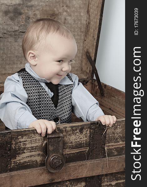 Baby boy playing inside an antique trunk. Baby boy playing inside an antique trunk