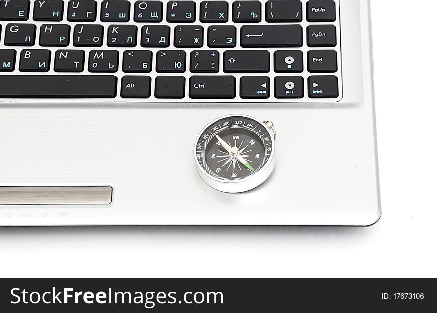 Compass on the laptop keyboard isolated on a white background