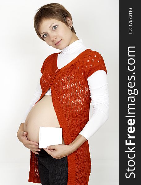 A pregnant woman is holding her stomach and a photo of her Ultrasound. Perfect photo for a love, motherhood, or a trimester concept.