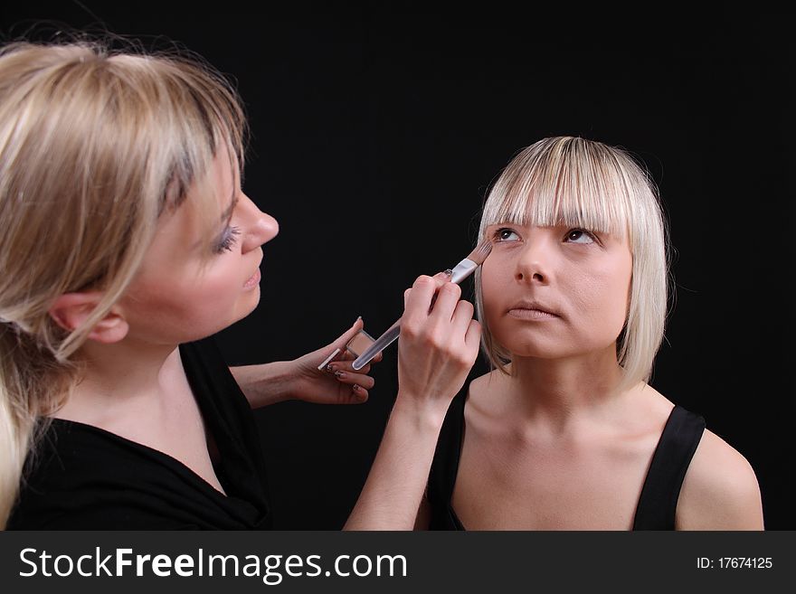 Stylist, cosmetologist doing make-up face with a brush. Stylist, cosmetologist doing make-up face with a brush