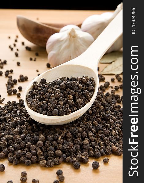 Garlic and black pepper on wooden spoon. Garlic and black pepper on wooden spoon