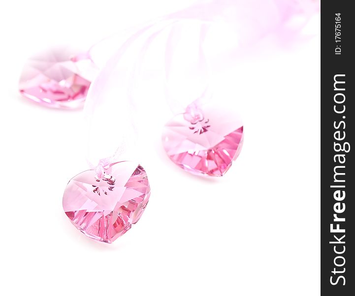 Three pink crystal hearts on a white background. Three pink crystal hearts on a white background.