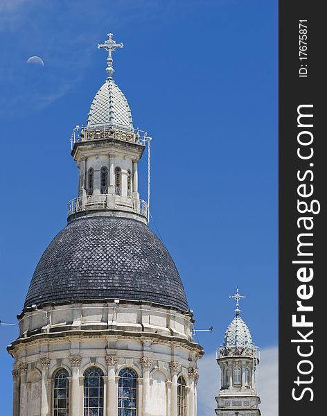 The main dome or cupola and a secondary tower of a Cathedral, at Rosario city, Argentina, with a blue sky and a half moon on the background. The main dome or cupola and a secondary tower of a Cathedral, at Rosario city, Argentina, with a blue sky and a half moon on the background.