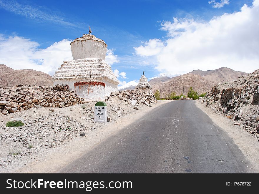 A road entering a distant Himalayan region with Buddhist stupa. A road entering a distant Himalayan region with Buddhist stupa.