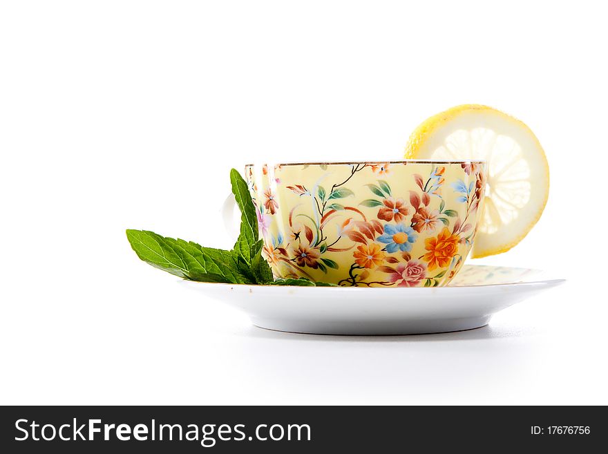 Cup of fresh tea with mint leaves and lemon