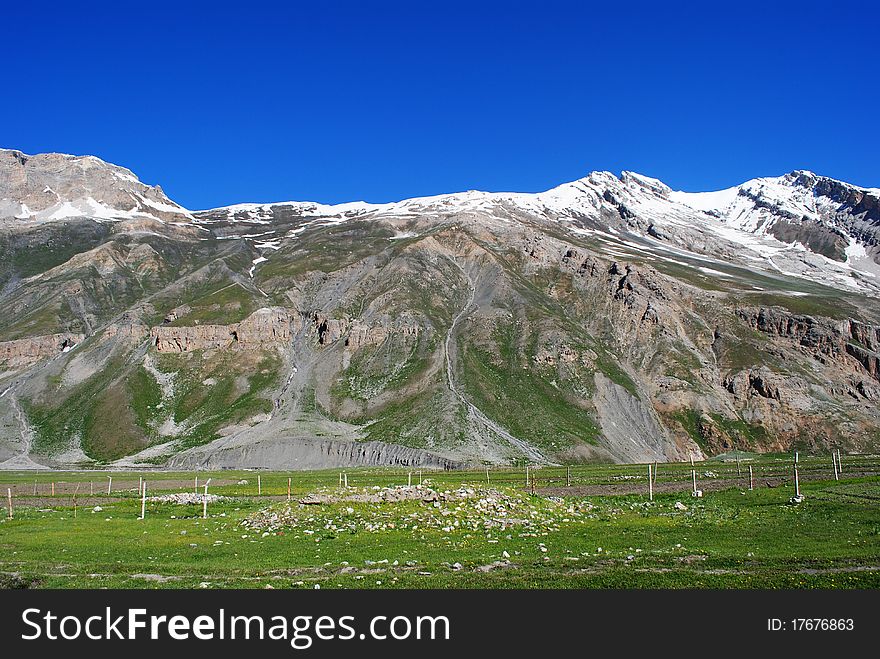 A beautiful landscape scene with vibrant greenery and snow-peak. A beautiful landscape scene with vibrant greenery and snow-peak.