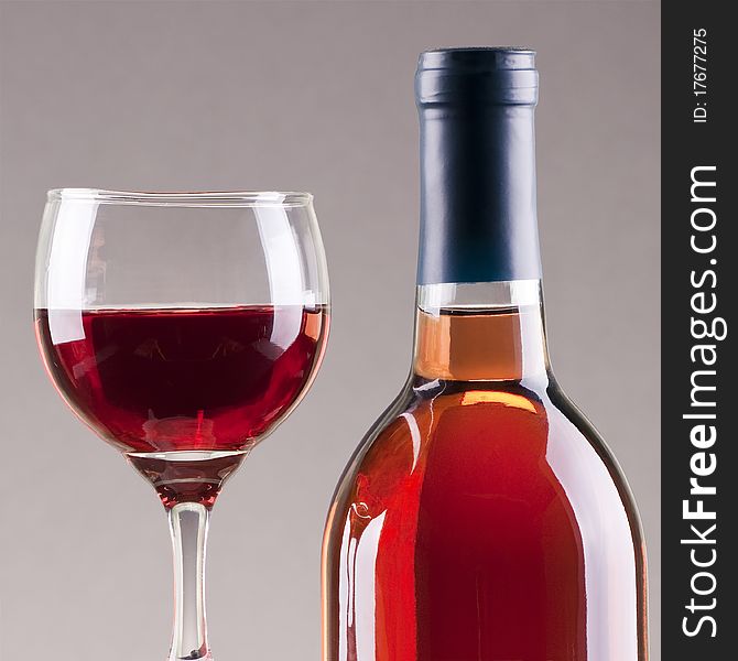 Glass and bottle of rose wine  with gray background