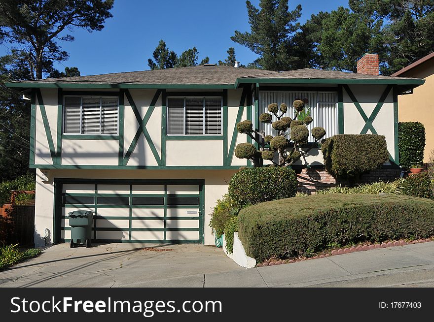 House surrounded by trees and grass with blue sky.