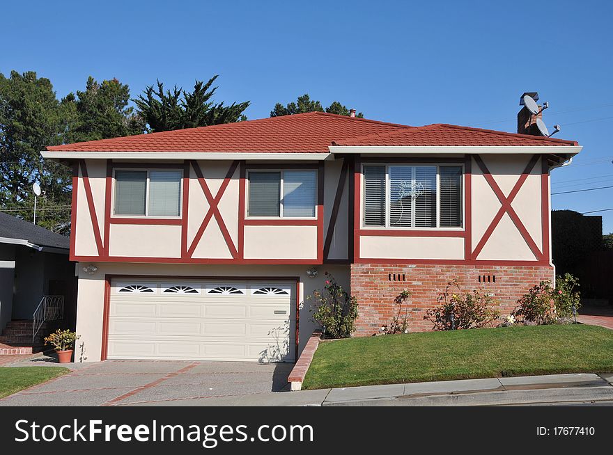 House surrounded by trees and grass with blue sky.